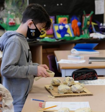 This is a collection of photos of students designing and making their relief sculptures out of newspaper and paper mache