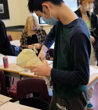 This is a collection of photos of students designing and making their relief sculptures out of newspaper and paper mache