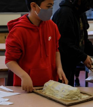 This is a collection of photos of students designing and making their relief sculptures out of newspaper and paper mache