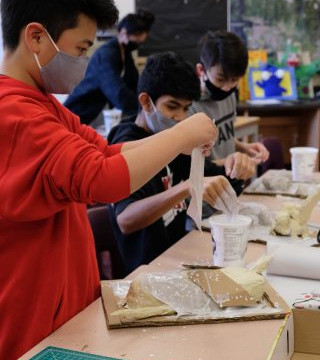 This is a collection of photos of students designing and making their relief sculptures out of newspaper and paper mache