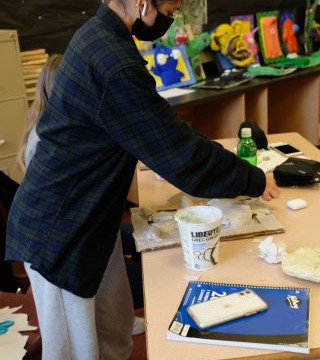 This is a collection of photos of students designing and making their relief sculptures out of newspaper and paper mache