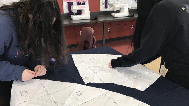 Students in the Textiles 9-12 class working on their pattern layouts for coats, pajama pants, flared pants and culottes.