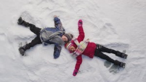 stock-footage-two-kids-in-winter-making-snow-angels